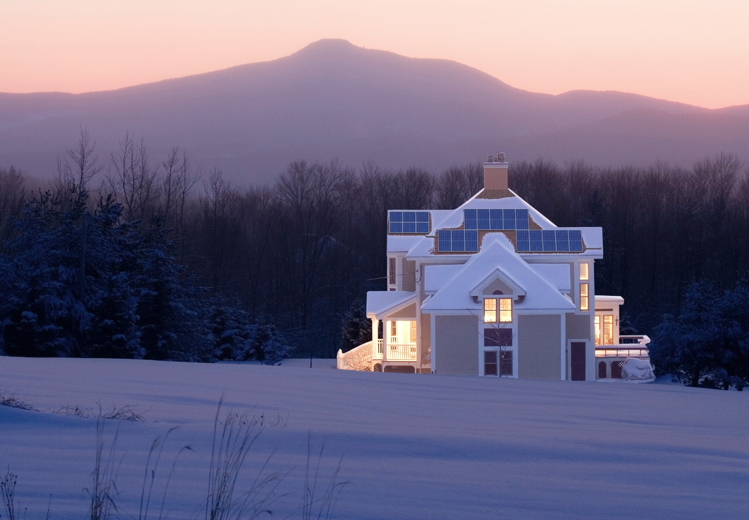 House with solar panels in snowy field